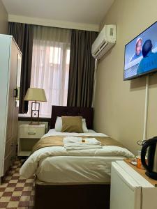伊斯坦布尔Fındık Palas Otel的一间卧室，有一张床，墙上有一台电视