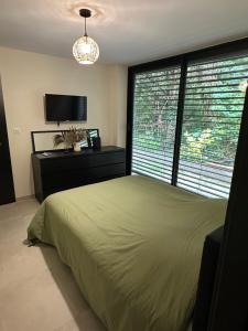 a bedroom with a bed and a large window at Garden secret in Strasbourg