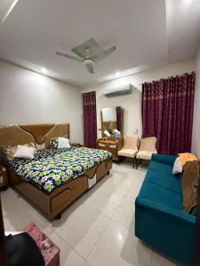 een slaapkamer met een bed en een blauwe bank bij gill house in Multan