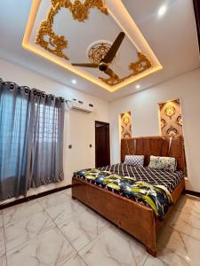 een slaapkamer met een bed en een plafond bij gill house in Multan