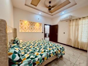 een slaapkamer met een bed met een kleurrijk dekbed bij gill house in Multan