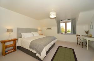 a bedroom with a bed and a desk and a window at The Steading at Legerwood in Earlston