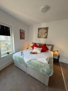 a bedroom with a bed with red pillows at Central Peterborough Studio 2 in Peterborough