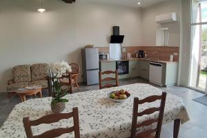 a kitchen with a table with a bowl of fruit on it at Le Colombier - Chambre Mésange in Baule +6 photos
