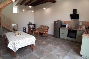 a kitchen with a table and a kitchen with a table and chairs at Le Colombier - Chambre Mésange in Baule