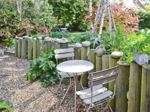 a table and chairs in a garden with a fence at Seasong in Salthouse