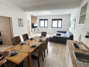 a kitchen and living room with a wooden table and chairs at RheinZeit Apartment Köln Bonn in Niederkassel