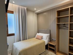 a small bedroom with a bed and a window at Hotel Vélez in Vélez-Rubio