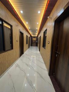 a hallway with marble floors in a building at Omji - Darshan Bhawan - 2km from Ram Janmbhumi Temple in Ayodhya