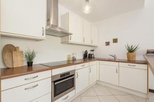 a kitchen with white cabinets and a stove top oven at Spanish Water Pier in Jan Thiel