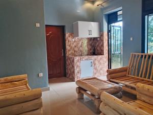 a living room with two wooden benches and a door at EAR KEN BARHAM GUESTHOUSE in Rwumba +45 photos