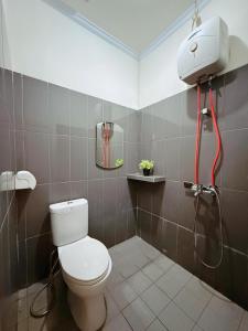 a bathroom with a toilet and a shower at URVANA Hotel By Majestra Hospitality in Kamparganya