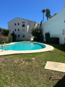 a swimming pool in a yard next to a building at Margolf Sun in Sitio de Calahonda
