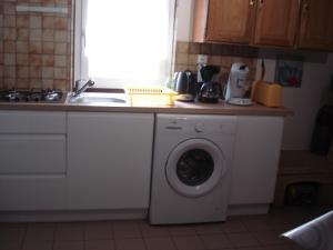 eine Küche mit Waschmaschine und Spüle in der Unterkunft Appartement Baie du Mont Saint Michel in Cherrueix