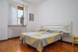 a bedroom with a bed with a yellow and white comforter at NEW - 4 pax - 10 min Milan Rho Fiera in Baranzate