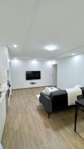 a bedroom with a bed and a couch in a room at Apparemment T2 in Albertville