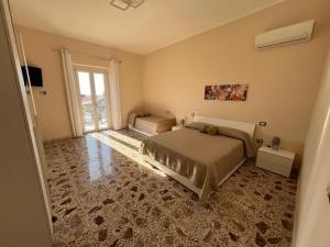 a bedroom with two beds and a large window at Villa Fava in Falciano del Massico