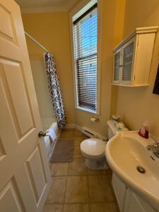 a bathroom with a toilet and a sink and a window at Westmount Manor Unit 1 - 2 Bedroom Apartment in St. John's