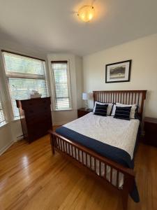 a bedroom with a large bed and two windows at Westmount Manor Unit 2 - 2 Bedroom Apartment in St. John's