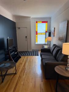 a living room with a black couch and a window at Westmount Manor Unit 2 - 2 Bedroom Apartment in St. John's