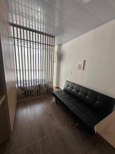 a black couch in a living room with a large window at Castellana 504 in Bogotá