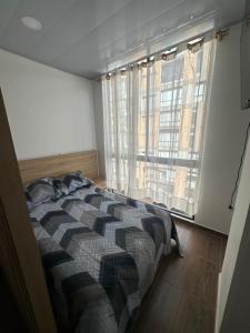 a bedroom with a bed and a large window at Castellana 504 in Bogotá