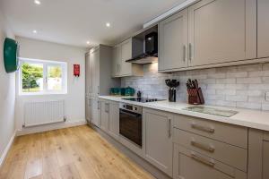 Countryside Hot Tub Games Area في Bunny: مطبخ بخزائن بيضاء وفرن موقد