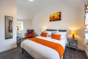 Countryside Hot Tub Games Area في Bunny: غرفة نوم مع سرير كبير مع وسائد برتقالية