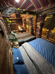 une chambre avec deux lits dans une cabane en rondins dans l'établissement Mộc HomeStay Trạm Tâu, à Trạm Tấu