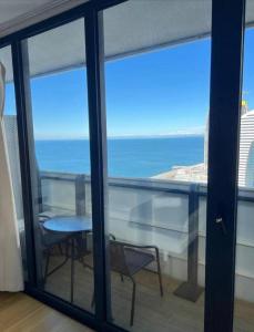 a view of the ocean from a balcony with a table and chairs at ORBI CITY NEW APARTMENTS Official BATUMI in Batumi