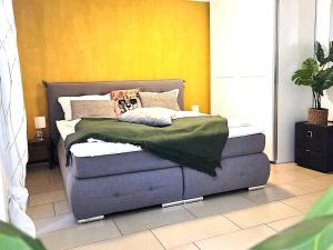a bed in a room with a yellow wall at Grüne Oase mit eigener Terrasse zwischen Altstadt und Hafen #3 in Senftenberg