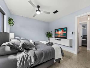 a bedroom with a bed with a ceiling fan at Luxury Stay with Filtered Water & Pet-Friendly Fun in Fort Lauderdale