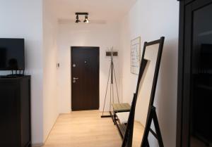 ein Flur mit einer schwarzen Tür und einem Stativ in der Unterkunft Moonlight Apartment in Timişoara