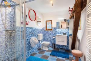 a blue tiled bathroom with a toilet and a shower at Offene Galerie-Fewo auf 2 Etagen in Bad Gandersheim +17 photos