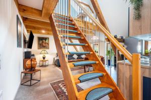 a wooden staircase with blue cushioned chairs in a living room at Offene Galerie-Fewo auf 2 Etagen in Bad Gandersheim