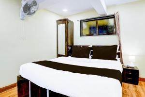 a bedroom with a white bed and a window at Hotel O Metro Galaxy inn in Mumbai