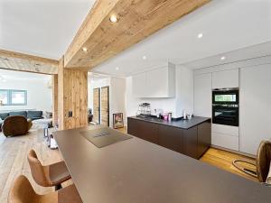 a kitchen and living room with a table and chairs at The Gathering Lodge - Crans Montana - Swiss Alps in Lens