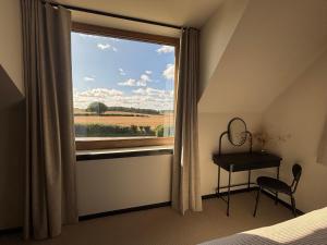 BulmerにあるKing room with private bathroom in Bulmer Streetの窓、デスク、テーブルが備わるベッドルーム1室が備わります。