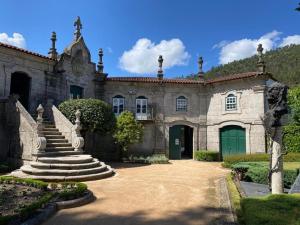 an old stone building with a green door and stairs at Canastro do Carvalho in Anissó