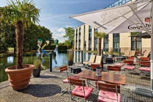 a patio with tables and chairs in front of a building at Four Points Flex by Sheraton Ratingen Düsseldorf Airport in Ratingen
