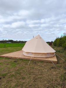 a large tent on a wooden platform in a field at Mardi talu Glamping 