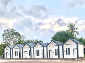 a row of white buildings with black roofs at AZ Roomstay Pendang in Pendang
