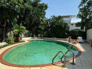 two women are sitting in a swimming pool at DUPLEXU PANAMA Homestay in Panama City