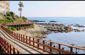 a wooden bridge over the ocean with a beach at Margolf Sun in Sitio de Calahonda