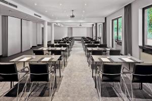 a row of tables and chairs in a room with windows at Four Points Flex by Sheraton Ratingen Düsseldorf Airport in Ratingen