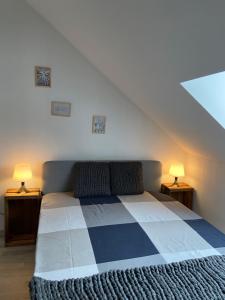 a bedroom with a blue and white bed with two lamps at Les COSY Apparts in Contrexéville