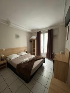 a bedroom with a large bed and a window at HOTEL DU MONT LOUIS in Paris +13 photos