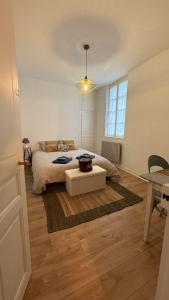 a bedroom with a bed and a table on a rug at L horizon d Aristide - 1 Chambre in Tulle