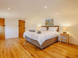 a large bedroom with a large bed and wooden floors at 2 Bed in Kings Nympton 87985 in Kings Nympton