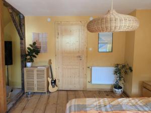 een slaapkamer met een bed en een gitaar in een kamer bij Ferienhaus Glockenklang in Sangerhausen